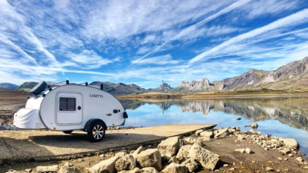 Modelo Caretta acampado junto a un lago y montañas, perfecto para viajes en libertad