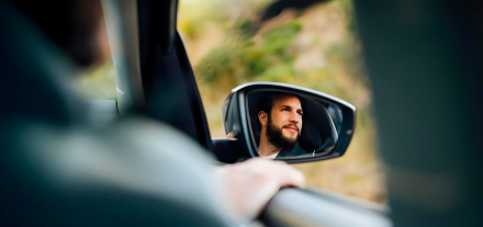 Viajero revisando por el retrovisor mientras conduce mini caravana