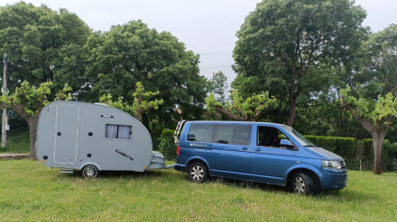 Limpiar el depósito de aguas grises de una minicaravana. minicaravana Caretta enganchada a una furgoneta en zona de acampada verde