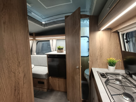 Detalle de cocina, baño y acabados en una minicaravana compacta